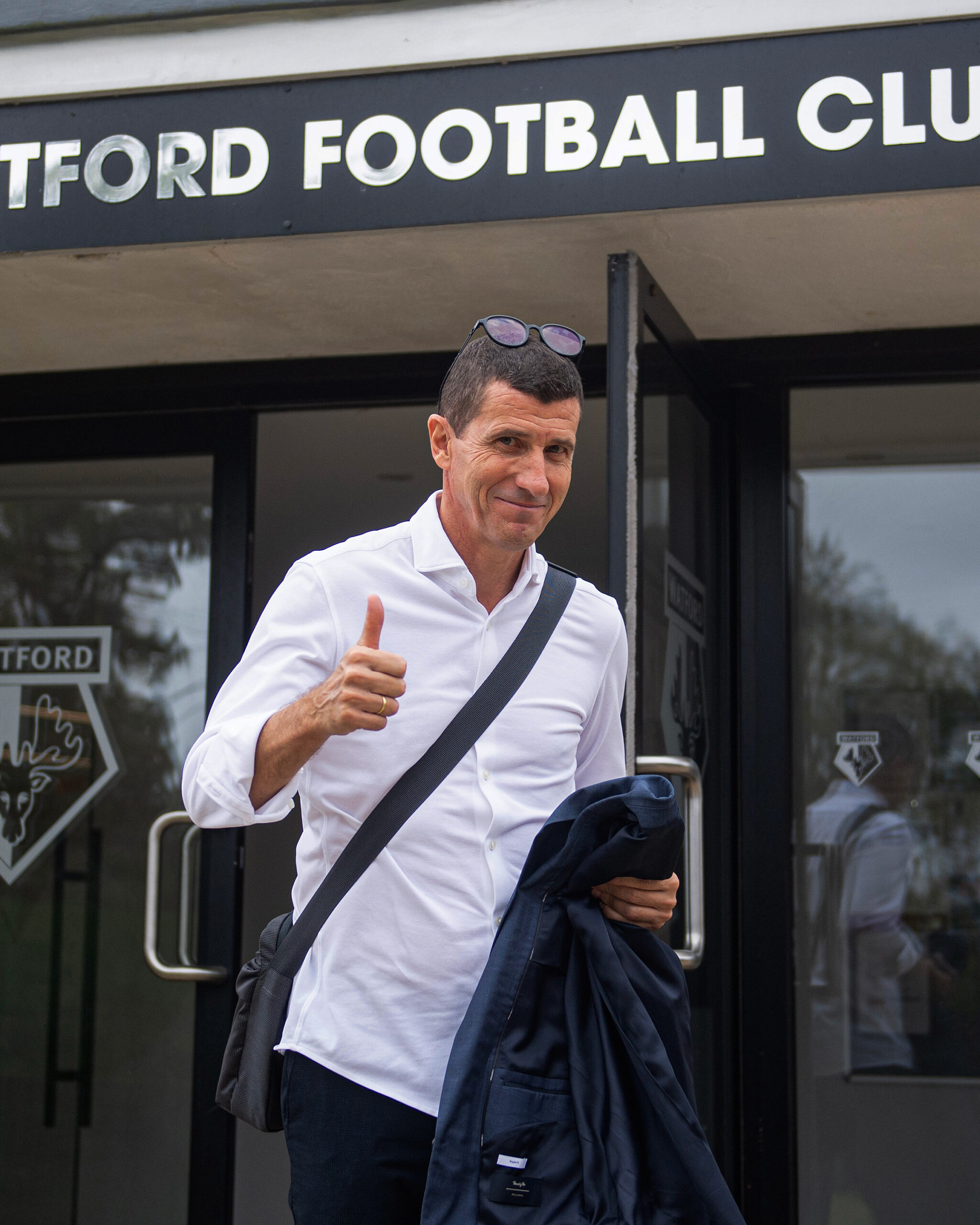Javi Gracia stands outside the Watford FC offices giving a thumbs up after agreeing to return as head coach, marking his second spell in charge of the club.