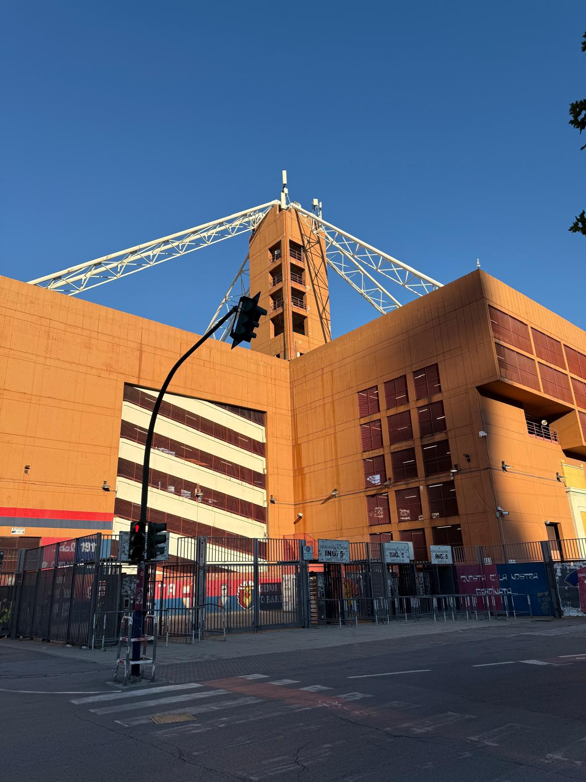 Photo taken outside Genoa’s Stadio Luigi Ferraris before the Genoa vs Lazio match, showing fans gathering near the entrance and the stadium’s distinctive brick-red towers in the background.