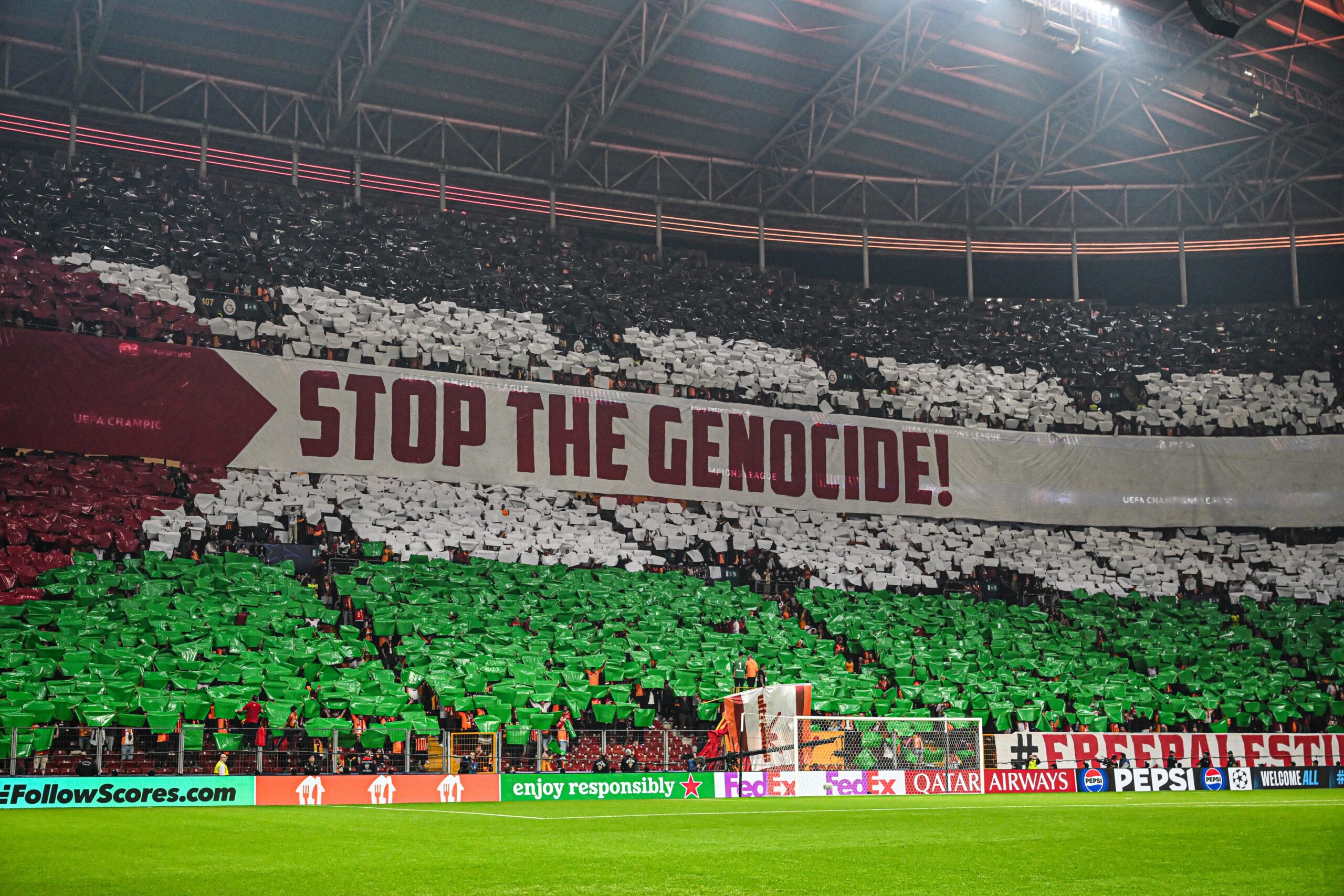 Galatasaray fans display a powerful stadium choreography reading “Stop the Genocide” alongside a large Palestine flag, creating a striking visual protest in support of Palestinians during a match.