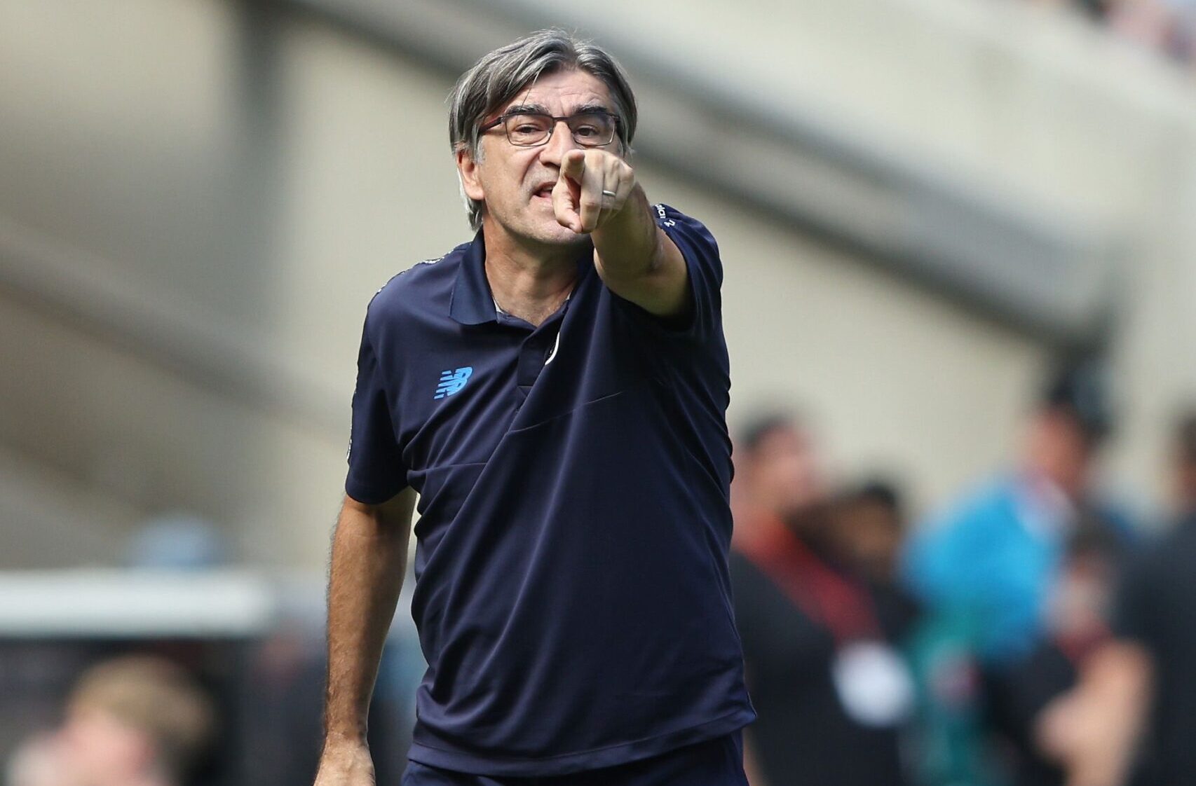 Ivan Juric stands on the touchline during an Atalanta match, animatedly giving tactical instructions to his players.