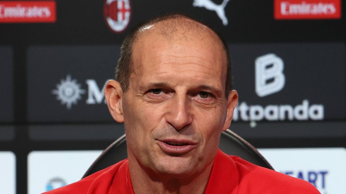 Massimiliano Allegri speaking during a press conference, seated in front of sponsor backdrops.