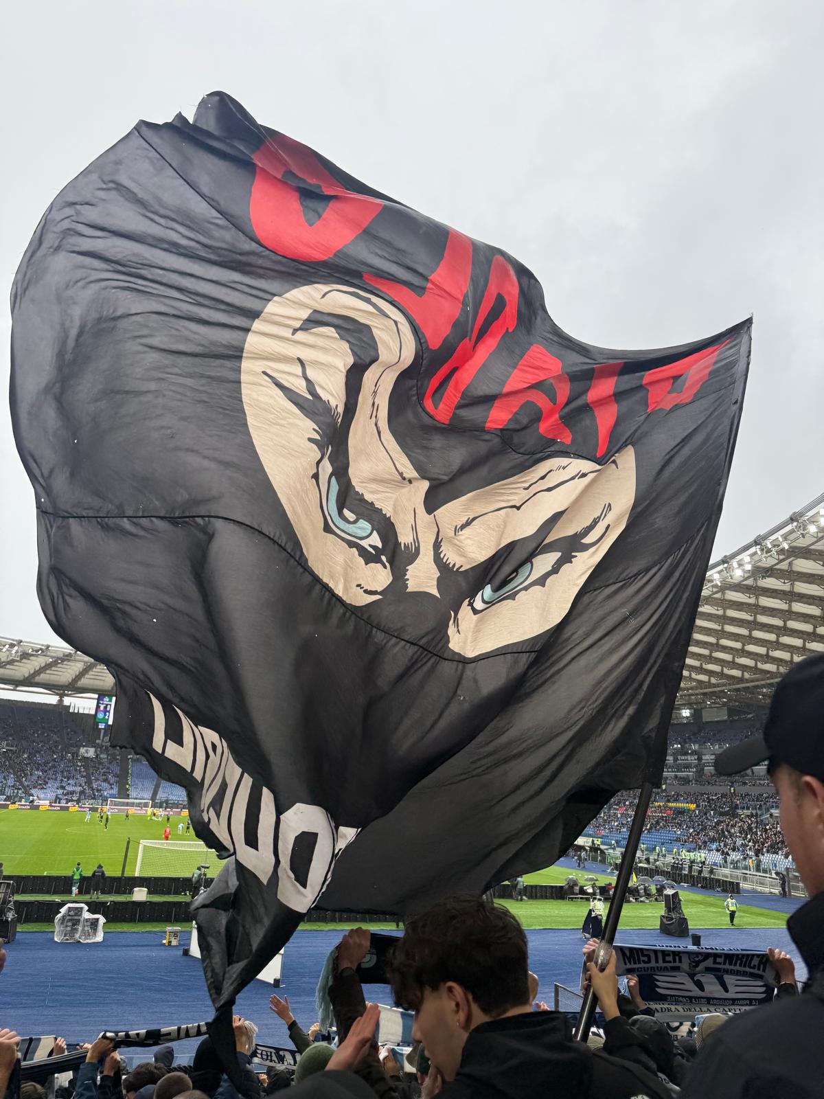 Ultras in the Curva Nord display a large Diabolik flag during the Napoli match, with flags and banners filling the stand.