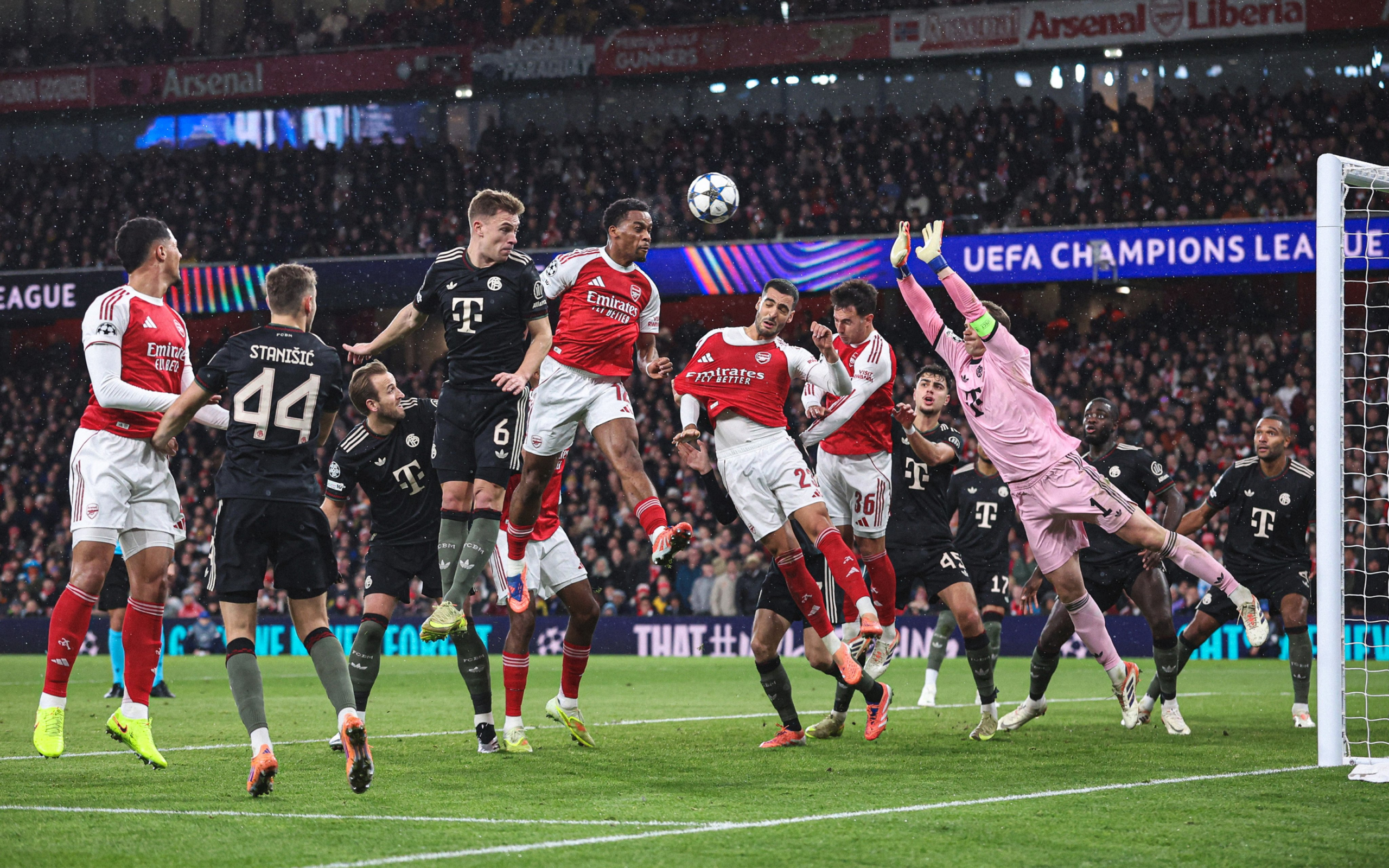 Arsenal and Bayern Munich players battle at a set-piece corner during the 2025-26 Champions League season.